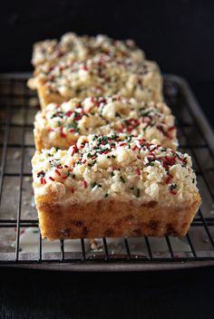 two pieces of cake sitting on top of a cooling rack with sprinkles