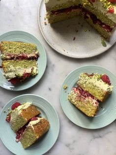 four slices of cake on plates with strawberries and raspberries in the middle