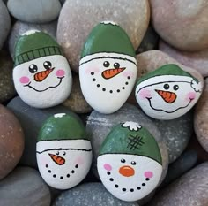 four painted rocks with snowmen on them