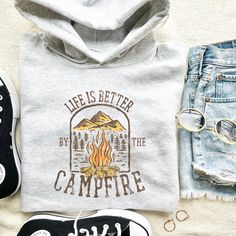 Life is Better by The Campfire Sweatshirt. HOW TO ORDER T-SHIRT 1- Please, Check and Review all Photos. 2- Choose your size from the drop-down menu 3- Select Your Shirt Color from Drop-down 2 4- Repeat for each shirt ordered 8 oz.(US) 13.5 oz.(CA), 50/50 preshrunk cotton/polyester Heather colors- 90/10 airlume combed and ringspun cotton/polyester Deep Heather Grey- 3.6 oz., 65% Polyester/35% Ring-Spun cotton Double-lined hood with color-matched drawcord Double needle stitching at shoulder, armho Campfire Hoodie, Adventure Cotton Hoodie With Letter Print, Hooded Sweatshirt With Letter Print For Camping, Hooded Letter Print Sweatshirt For Camping, Casual Cotton Hoodie For Camping, Winter Adventure Hoodie With Graphic Print, Winter Camping Hoodie With Letter Print, Graphic Print Hoodie For Adventure In Fall, Graphic Print Hoodie For Fall Adventure