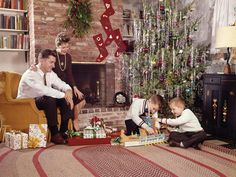 an old photo of two boys playing with toys in front of a christmas tree and fireplace