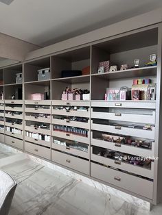 the shelves are full of cosmetics and other personal care items in this room, with marble flooring