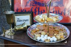 a three tiered tray filled with gold and white candies next to a framed photograph