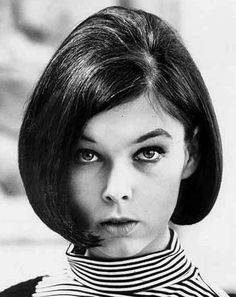 a black and white photo of a woman with short hair wearing a collared shirt