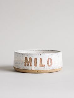 a white ceramic bowl with the word melo written in brown on it's side