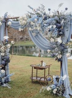 a blue and white wedding arch decorated with flowers