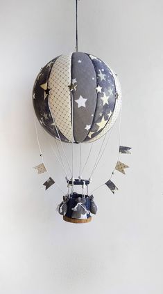 a hot air balloon with stars hanging from it's side