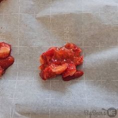 two pieces of fruit sitting on top of a piece of wax paper next to each other