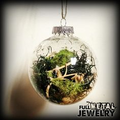 a glass ornament with moss and mushrooms in it