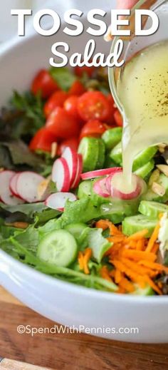 someone pouring dressing into a salad in a bowl