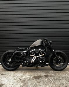 a black motorcycle parked in front of a garage door