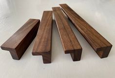 four pieces of wood sitting next to each other on a white counter top with one piece missing