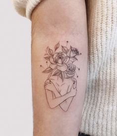 a woman's arm with a flower and heart tattoo on the left inner arm