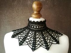 a white mannequin with black crochet on it's neckline