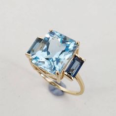 This stunning ring is set in 14k Solid Yellow Gold with Natural Sky Blue Topaz & London Blue Topaz with utmost precision. It is an unique statement gemstone ring for nearly every occasion and is completely hassle-free jewelry. ITEM DETAILS * CENTER GEM: Sky Blue Topaz * GEM SIZE: 10X12mm * GEM SHAPE: Octagon (Emerald Cut) * GEM WEIGHT: 7.35 carats * SIDE GEM: London Blue Tooaz * GEM SIZE: 3x6mm (2pc) * GEM SHAPE: Baguette * GEM WEIGHT: 0.75 carats * Total GEM WEIGHT: 8.10 carats * Gold Purity: 1 Sky London, Jewelry 2024, Sky Blue Topaz Ring, Gold Skies, Blue Topaz Jewelry, Smoky Quartz Ring, Teal Sapphire, Sophisticated Bride, Topaz Jewelry