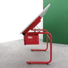 a red chair with a white table top on it's back and wheels attached to the seat