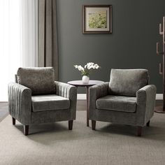 two blue chairs sitting next to each other in a living room