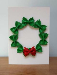 a white card with green leaves and a red bow