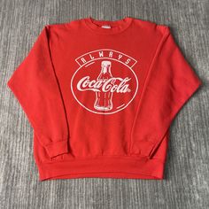 a red sweatshirt that says always coca cola on it