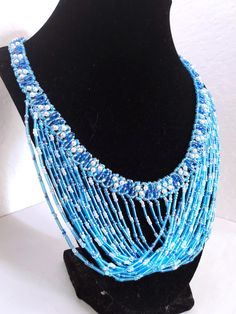 A handmade glass beaded necklace that is perfect for any occasion: parties, holidays, birthdays, anniversaries. All products are hand-crafted by my mother. Dimensions: - Length: 28.5 cm - Width: 22.0 cm - Height: 2.0 cm Lightweight, high quality with a beaded hook as a clasp.  Acrylic Pearls: 8 mm. Will respond to concerns and suggestions promptly. Shipping costs: Free Domestic Shipping. All orders are sent by air-mail with tracking number. Time of delivery: Estimated 1-3 days for domestic shipping; international make take 7-14 days. Feel free to check out our other similar products! https://noorsjewelers.etsy.com Bohemian Blue Necklace For Celebration, Adjustable Blue Beaded Necklaces For Party, Adjustable Turquoise Beaded Necklaces For Party, Blue Necklaces With Colorful Beads For Party, Turquoise Beaded Necklace With Dangling Beads For Party, Handmade Turquoise Necklace For Celebration, Blue Beaded Necklaces With Polished Beads For Wedding, Turquoise Beaded Necklace With Colorful Beads For Parties, Blue Round Bead Necklaces For Parties