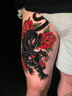 a black panther with roses on his thigh