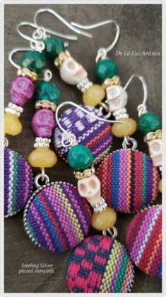 some colorful beads are hanging from earrings on a table and there is also a pair of earwires