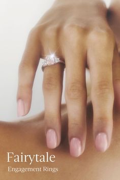 a close up of a person's hand with a diamond ring on their finger