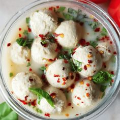 a small glass bowl filled with mozzarella and basil garnished with red pepper