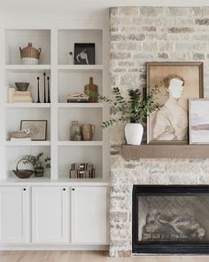 a living room filled with furniture and a fire place in front of a brick wall