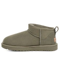 The UGG Classic Ultra Mini Boot in Moss Green offers a sleek and modern take on the classic UGG style. Crafted from premium suede and lined with cozy sheepskin, this boot provides both comfort and style. Its low-cut design makes it easy to slip on and off, perfect for casual wear. The rich moss green color adds a touch of earthy elegance to any outfit. Green Uggs Boots Outfit, Green Mini Uggs, Green Ugg Boots, Green Uggs, Uggs Outfit Ideas, Uggs Mini, Ugg Green, Ultra Mini Ugg, Wishlist Christmas