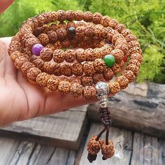 "This Chakra Mala is made with 108 x 9mm Rudraksha beads that are naturally stained and oiled to achieve their  aged appearance and 7 stones representing the 7 chakras. There are 108 Rudraksha beads - 27 between the Om Mani Padme Hum in Tibetan script Inscribed Guru Bead and the first and seventh Chakra stones and 9 between each of the Chakra stones  📿Mala Beads, or Buddhist prayer beads, are a set of sacred rosary beads for chanting & counting mantras, meditation, prayer, yoga & reflection. Mala is a Sanskrit word meaning garland. The Tibetan word for mala is threngwa (Tibetan  ཕྲེང་བ) . Seed malas are some of the most common malas used in Tibet and Nepal. Buddhist Prayer Beads are sometimes referred to as Japa mala, japa is a Sanskrit word meaning \"repeat internally\".📿 Specifications 108 Beads Jewelry For Healing And Festivals, Healing 108 Beads Jewelry For Festivals, Spiritual Beaded Bracelets For Rituals, Spiritual Wooden Beads Bracelets For Festivals, Spiritual Beaded Bracelets For Festivals, Spiritual Round Beads Mala For Puja, Spiritual Mala With Round Beads For Puja, Spiritual Mala For Puja With Round Beads, Spiritual Gemstone Beads Bracelet For Festivals