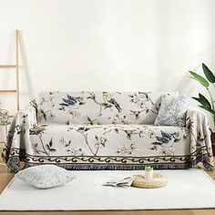 a living room with a couch and rug on the floor in front of a white wall