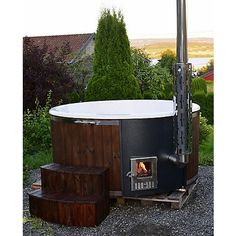 an outdoor hot tub with steps leading up to it and a fire place in the middle