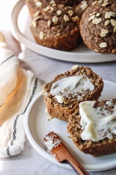 two white plates topped with muffins covered in frosting and oatmeal