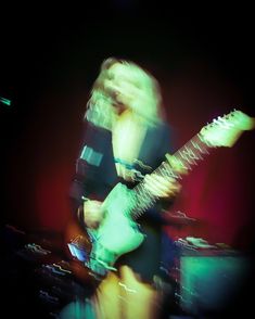 a blurry photo of a woman playing an electric guitar