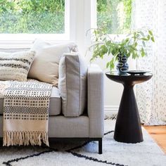 a living room with a couch, table and window in it's centerpiece