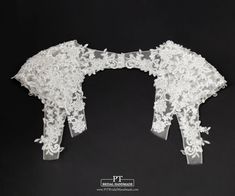 two white wedding garters on a black background