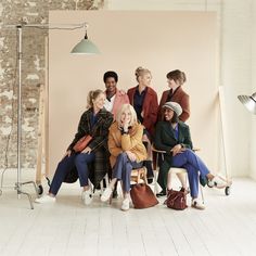 a group of people sitting next to each other in front of a brick wall and floor