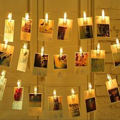 some pictures and candles are hanging on a string with lights in the middle of them