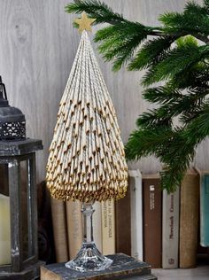 a christmas tree made out of sticks on top of a wooden table next to books