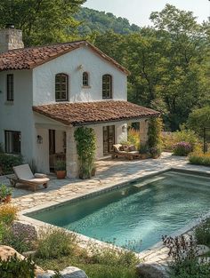 a house with a pool in front of it surrounded by greenery and trees,