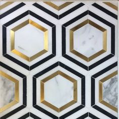 a marble and gold hexagonal tile wall with black and white geometric designs on it