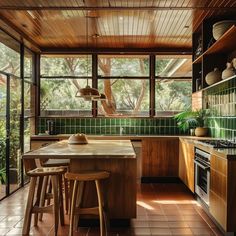 a kitchen with wooden cabinets and green tile flooring next to an open - air dining area