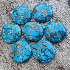 six blue rocks sitting on top of a wooden table