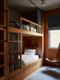 a bedroom with bunk beds in it and a chair next to the bed on the other side