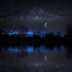 the night sky is lit up with stars and moon in the distance, as seen from a lake