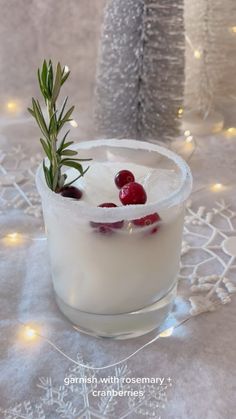 a glass filled with ice and cranberries on top of a white table cloth