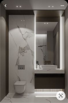 a modern bathroom with white marble walls and flooring, along with an illuminated mirror above the toilet