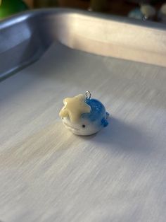 a small blue and white object sitting on top of a metal tray in front of an apple