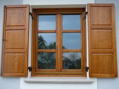 an open window with wooden shutters on the outside